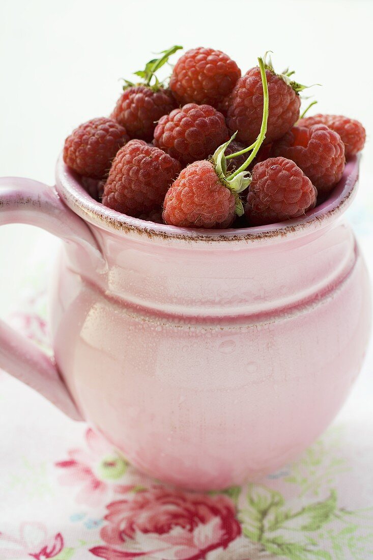 Frische Himbeeren im rosa Krug