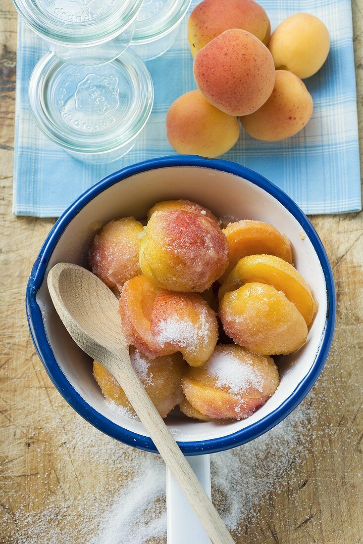 Sugared apricots in a pan, preserving jars, apricots