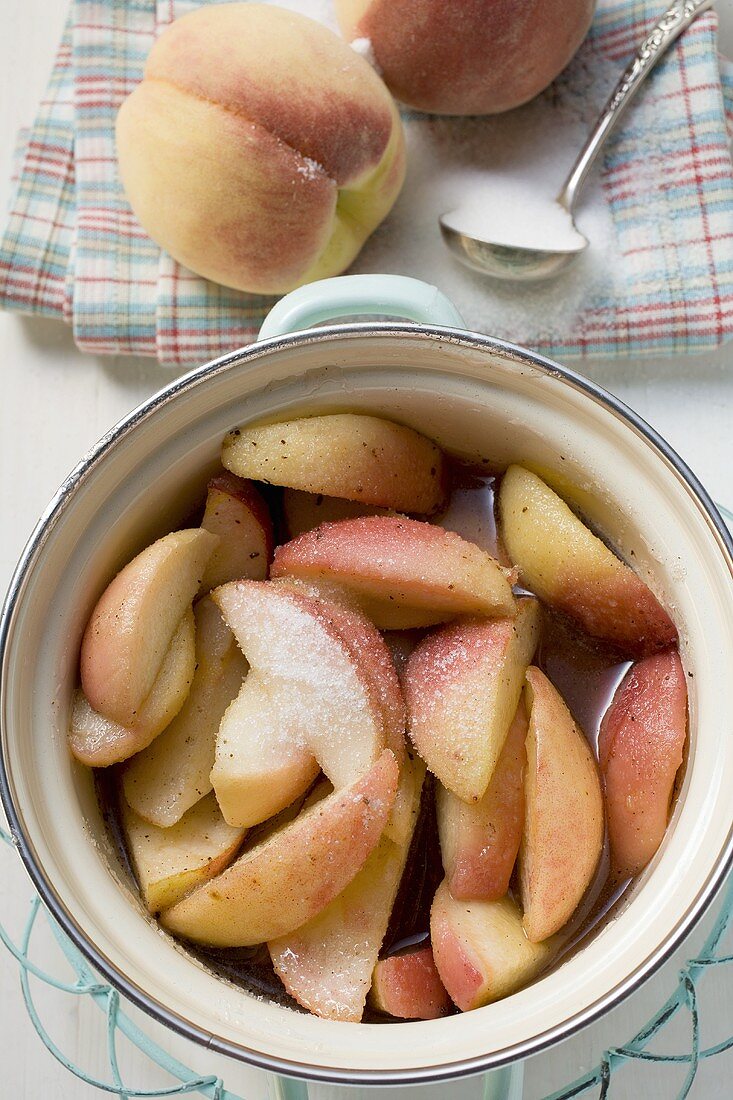 Gezuckerte Pfirsiche mit Wasser im Kochtopf