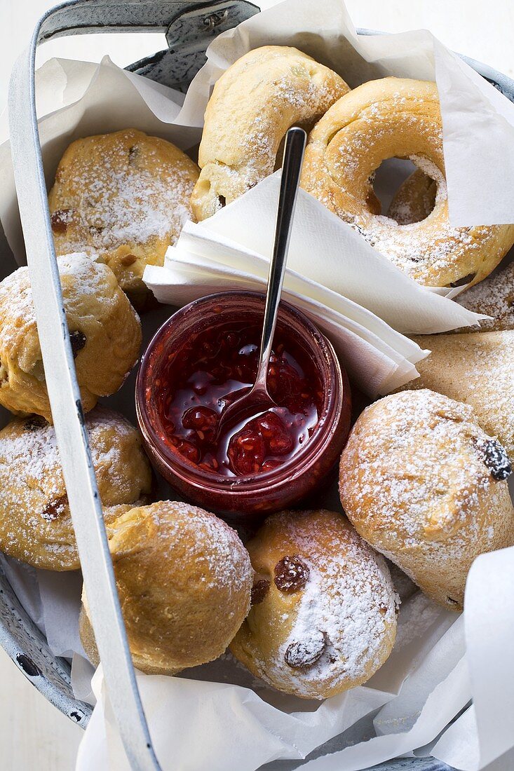 Rosinenbrötchen und Glas Beerenmarmelade