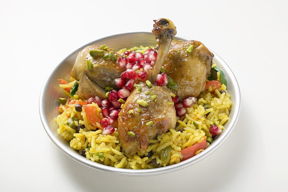 Chicken legs with saffron rice and pomegranate seeds