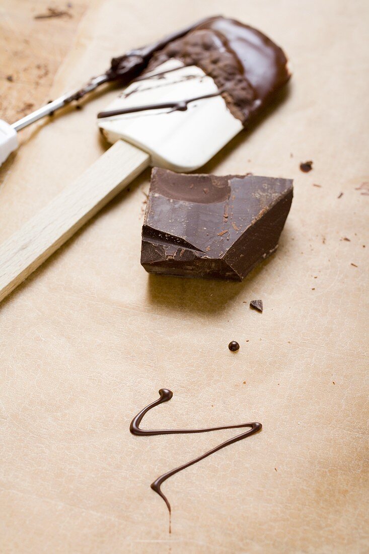 Piece of chocolate, remains of couverture, baking utensils