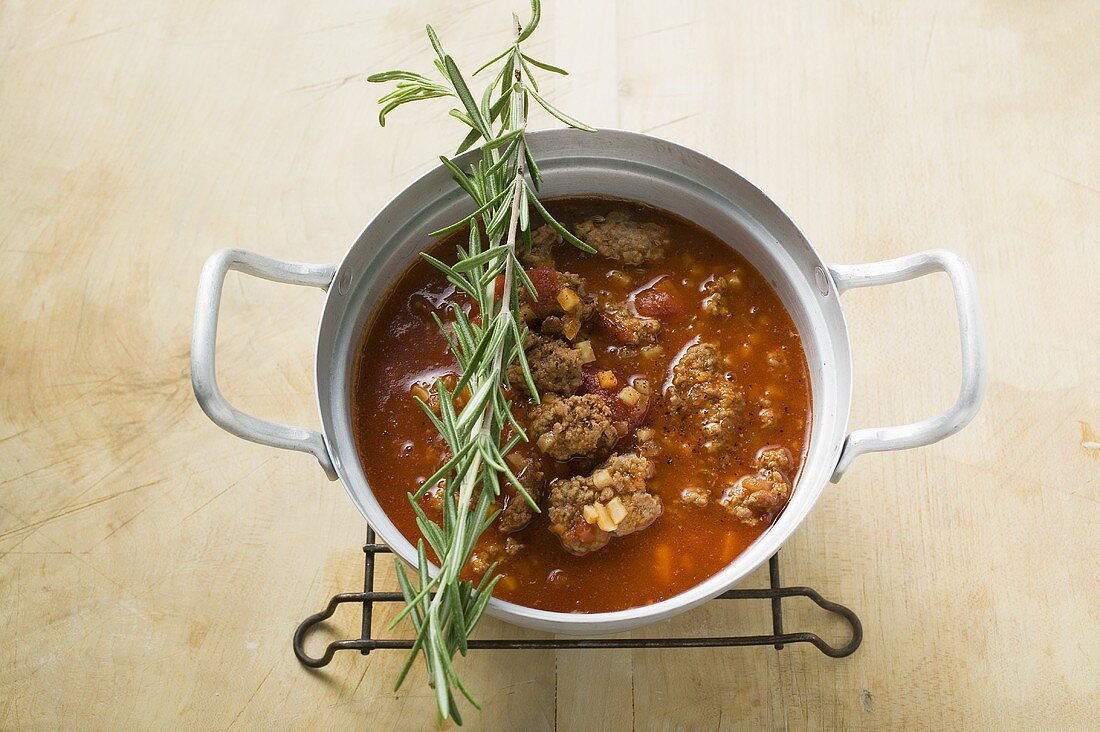 Hackfleischragout im Kochtopf, darauf frischer Rosmarin