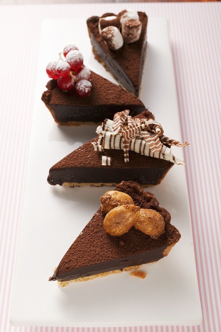 Four pieces of chocolate tart, with different decorations