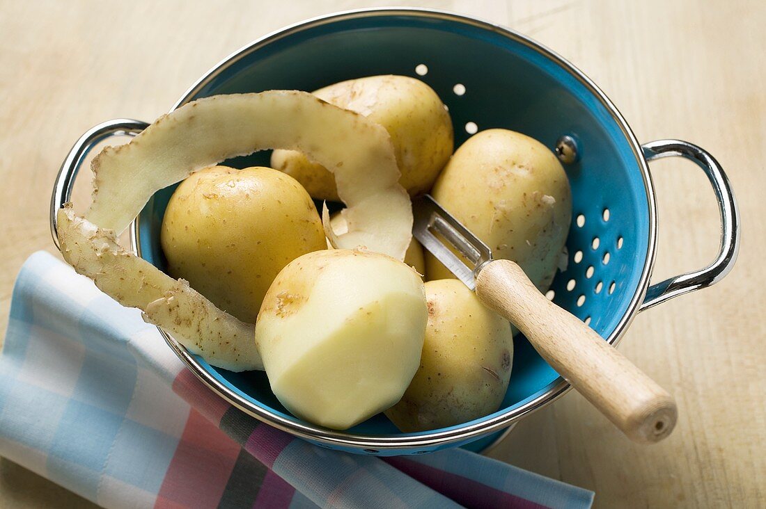 Potatoes, one half-peeled, in colander