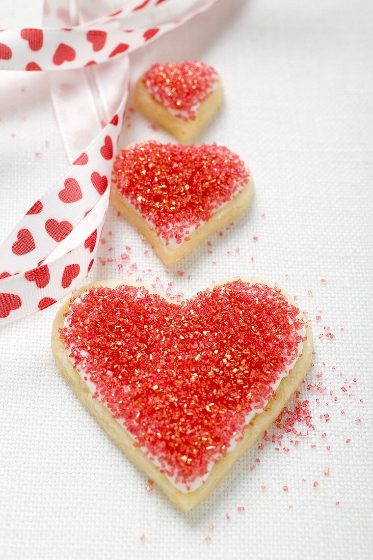 Three heart-shaped biscuits with red sugar