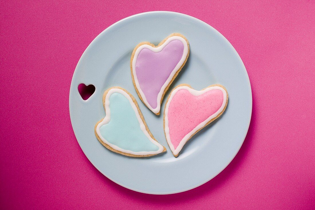 Drei herzförmige Plätzchen mit Zuckerglasur zum Valentinstag