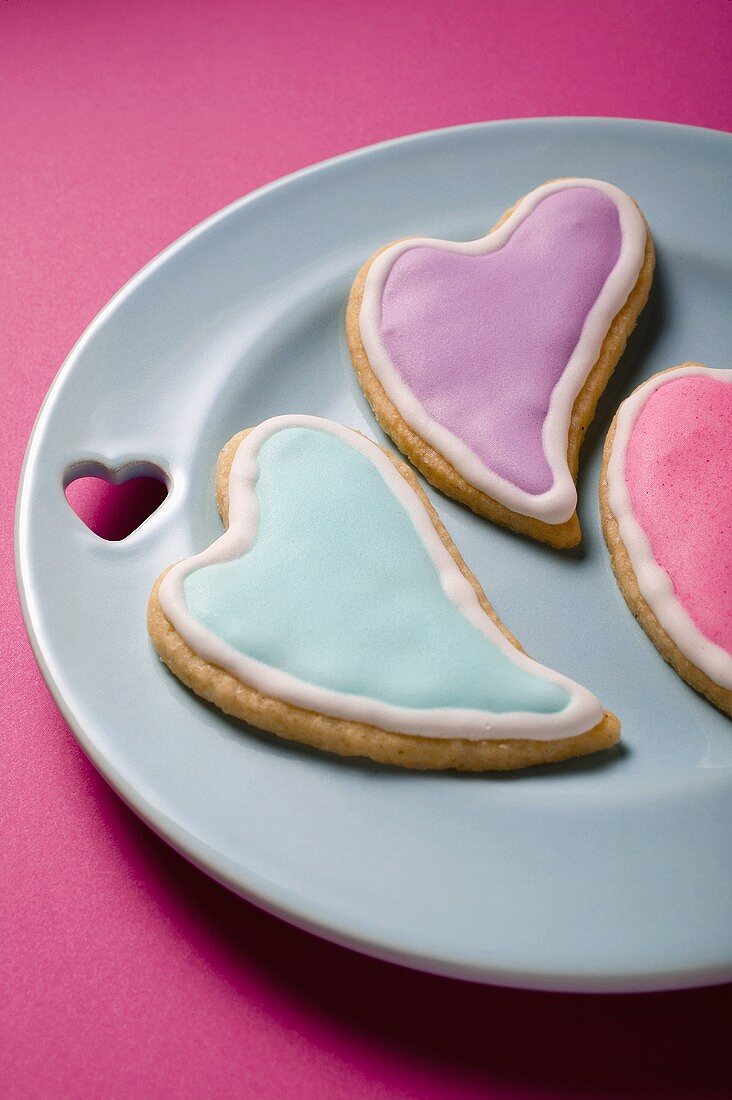 Drei herzförmige Plätzchen mit Zuckerglasur zum Valentinstag