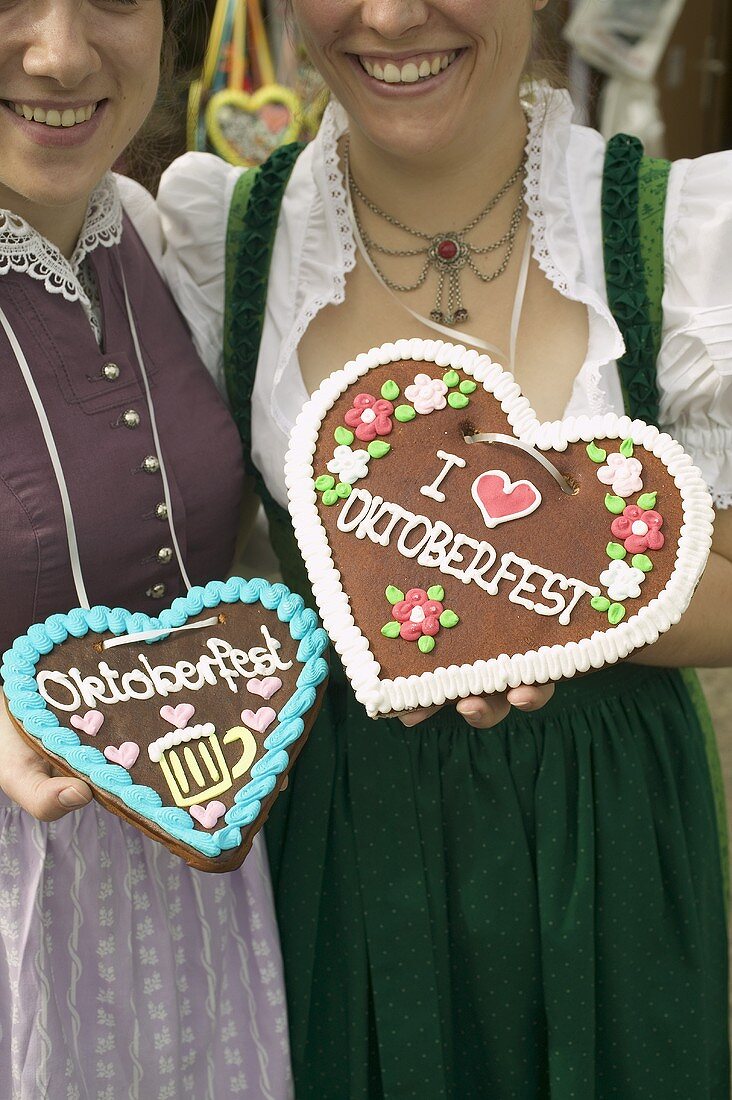 Two women in national dress with Lebkuchen hearts at Oktoberfest