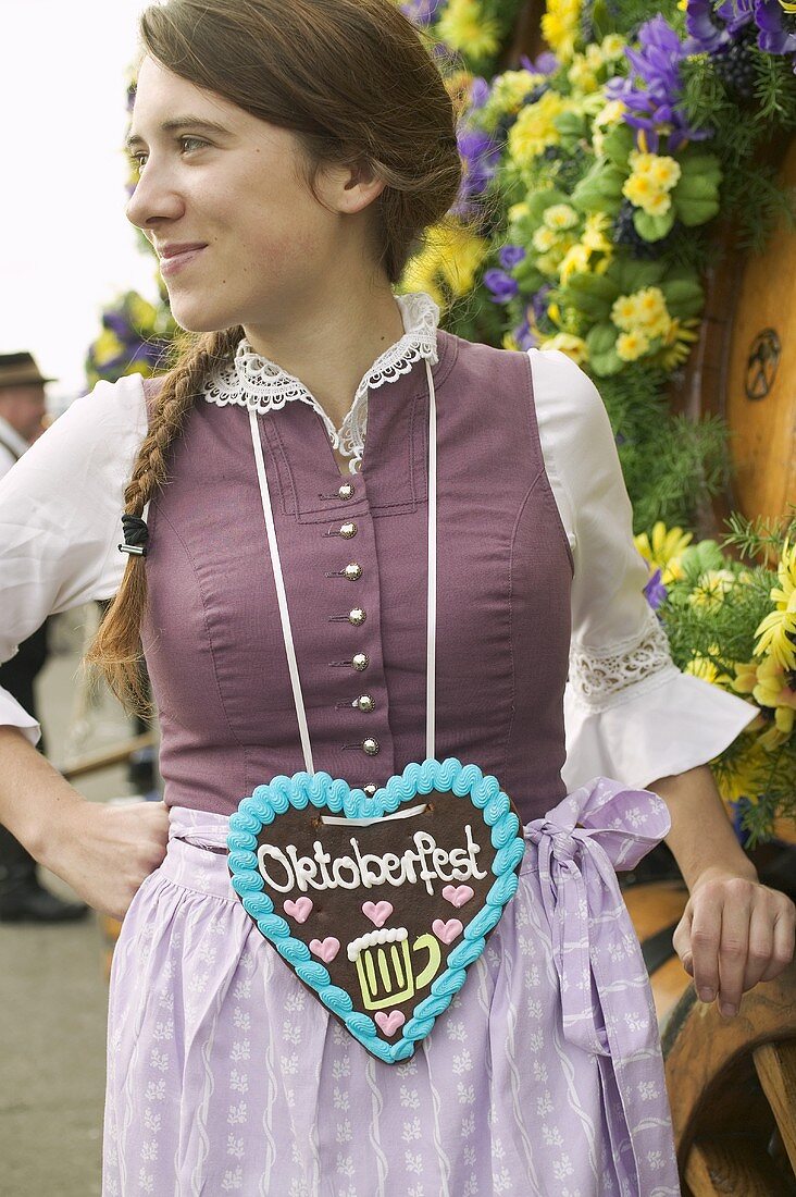 Frau in Tracht mit Lebkuchenherz beim Oktoberfest