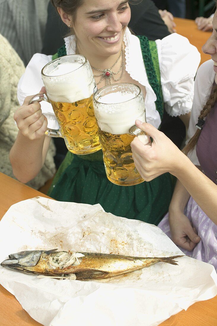 Zwei Frauen stossen mit Mass Bier an beim Oktoberfest