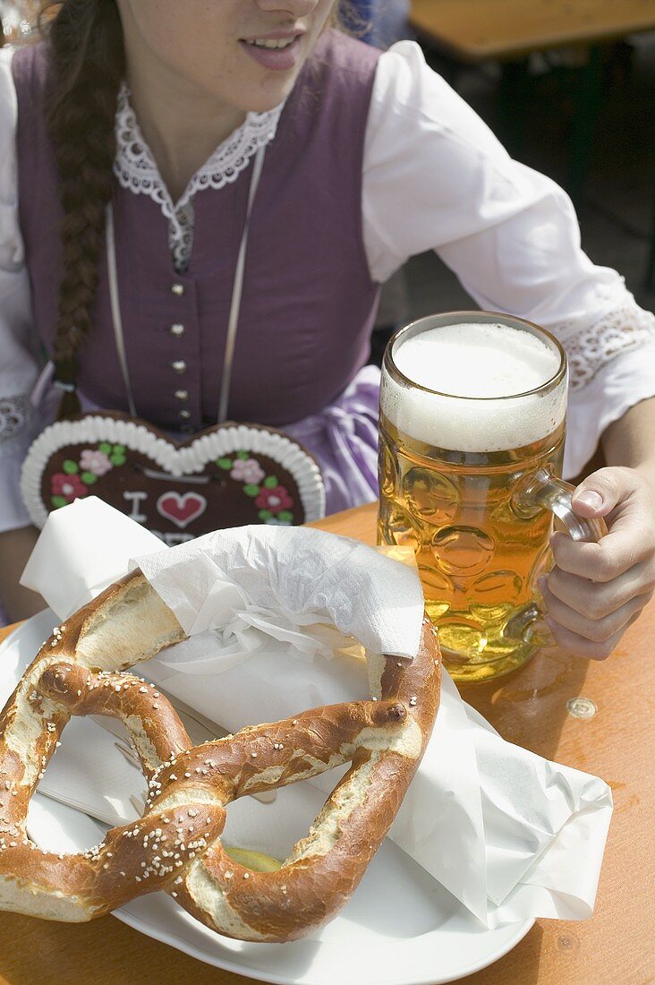 Woman with litre of beer and pretzel at Oktoberfest