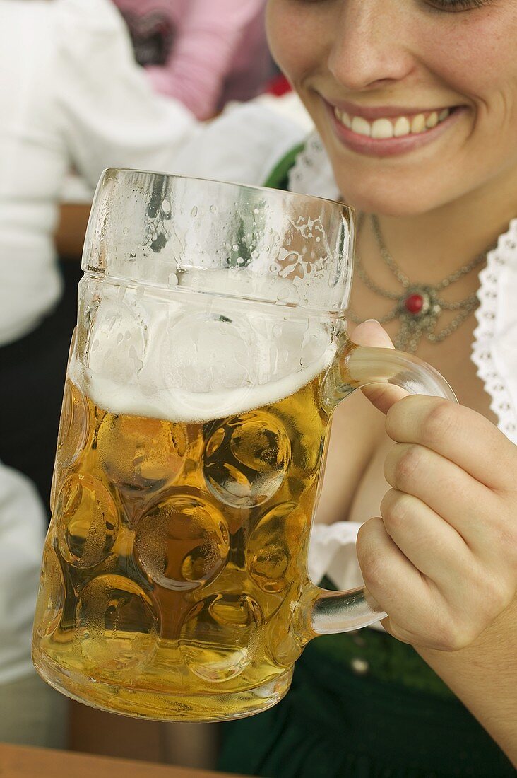 Woman drinking a litre of beer at Oktoberfest