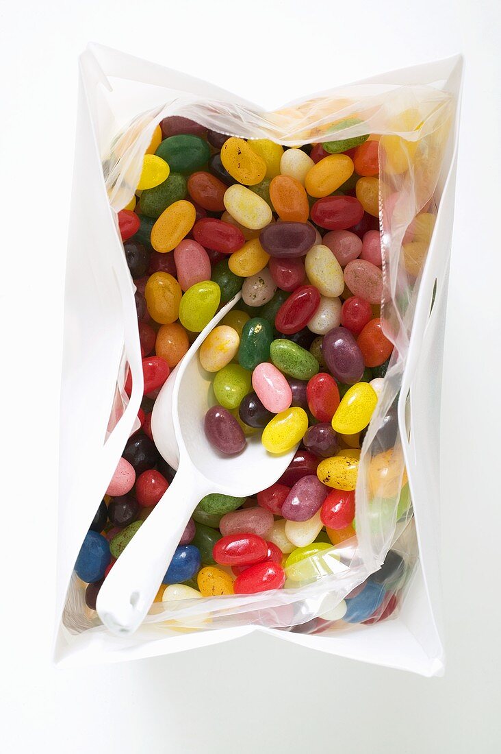 Bunte Jelly Beans in Plastiktüte mit Schaufel (Draufsicht)