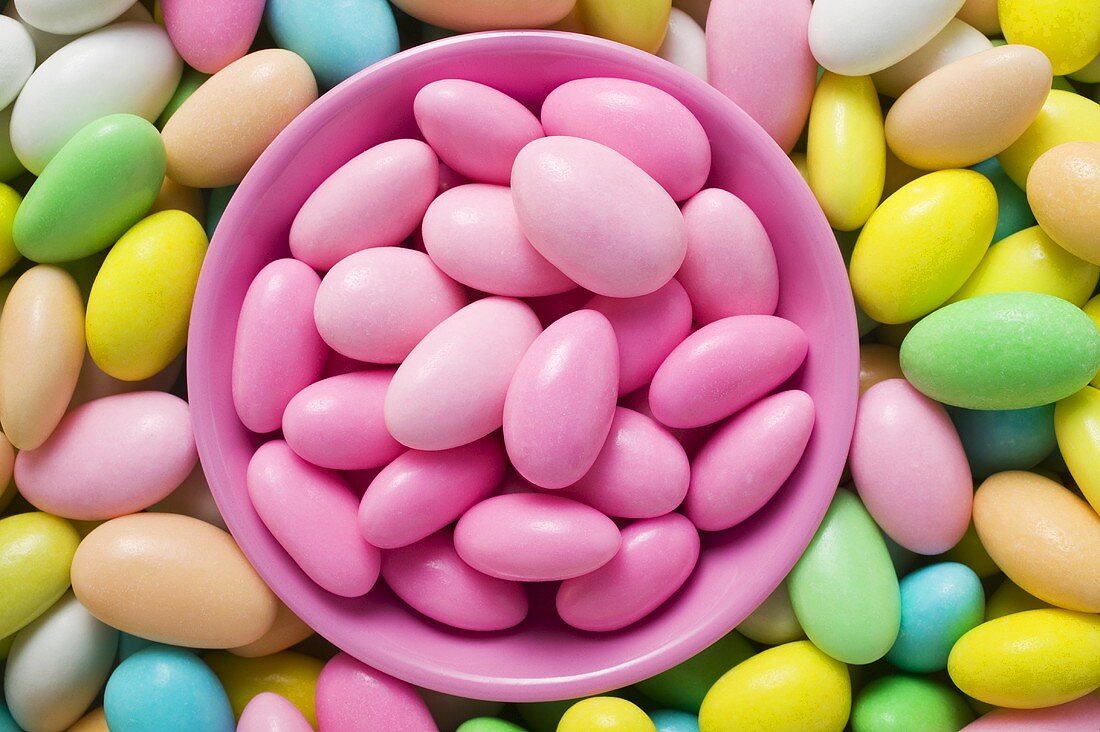 Sugared almonds, in and around pink bowl