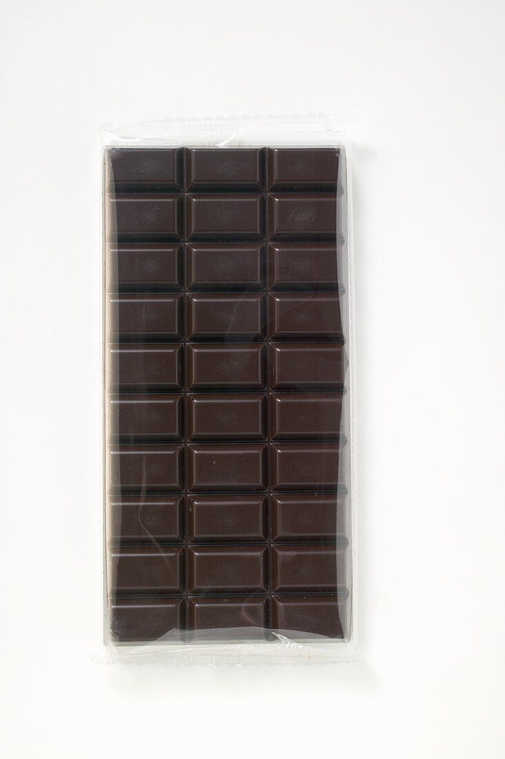 A bar of dark chocolate in cellophane