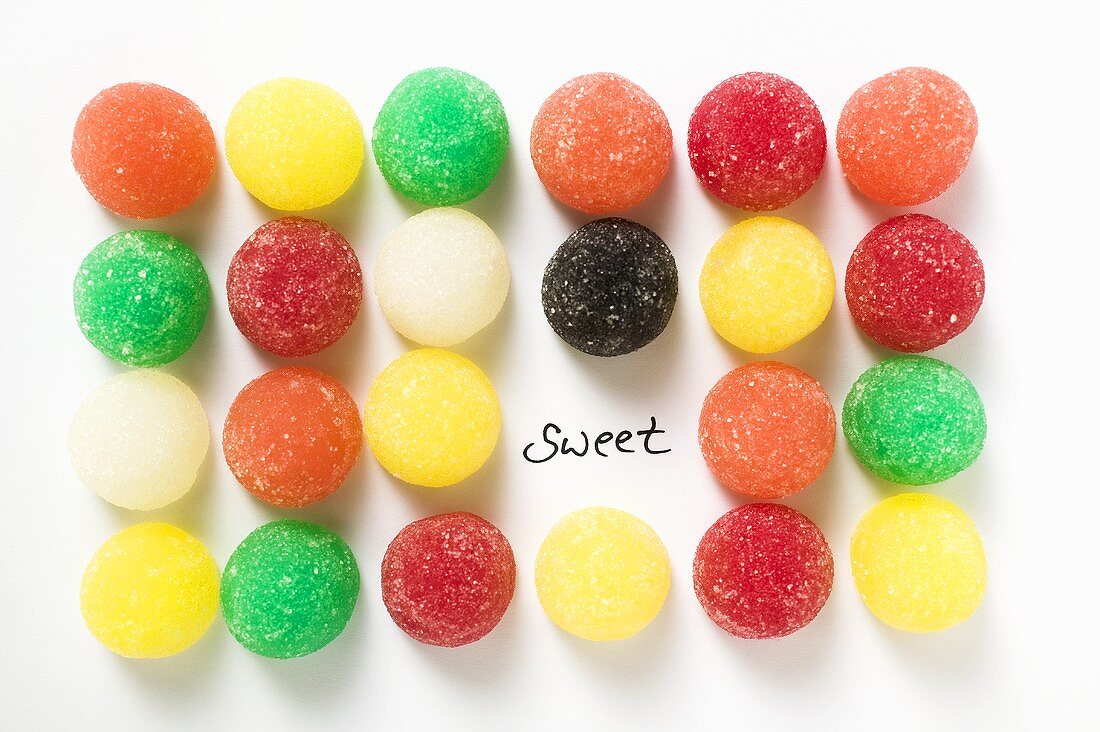 Viele bunte Geleebonbons in Reihen mit Schriftzug Sweet