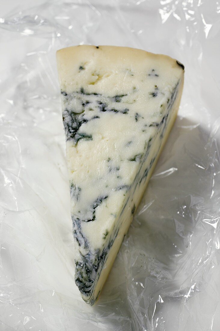 Stück Blauschimmelkäse auf Frischhaltefolie