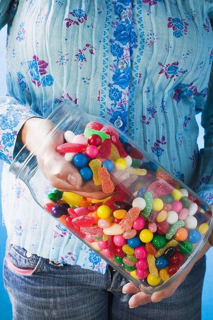 Hand taking sweets out of jar