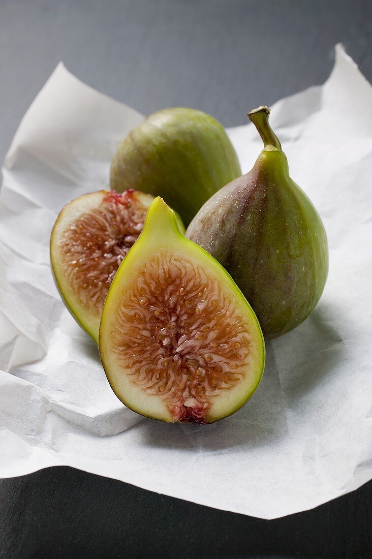 Three figs on paper, one halved