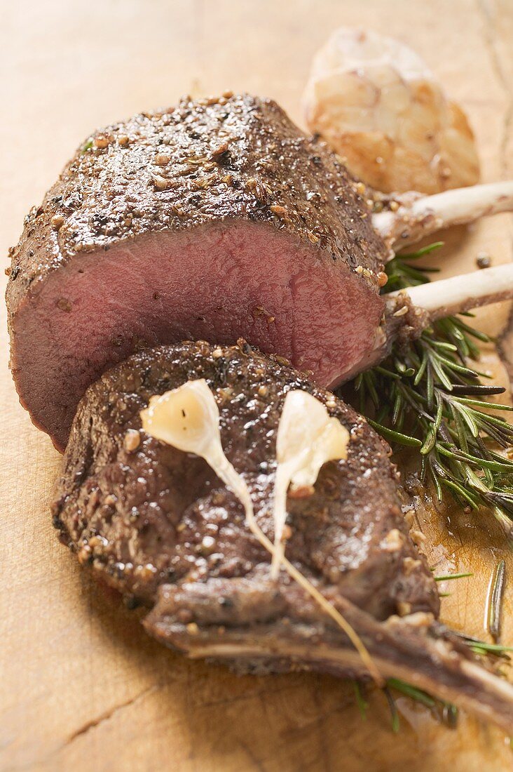 Rack of venison, partly carved, with garlic and rosemary