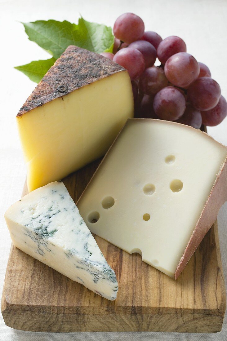 Various types of cheese and red grapes