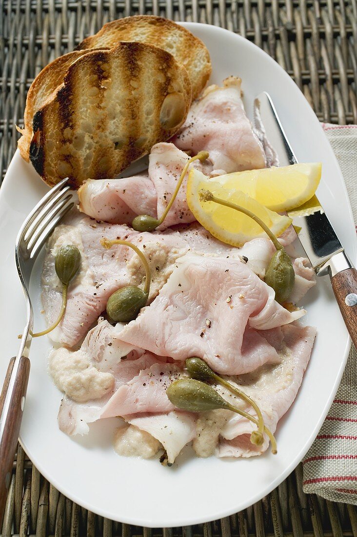 Kalter Schweinebraten mit Kapern, Zitronen und Toastbrot