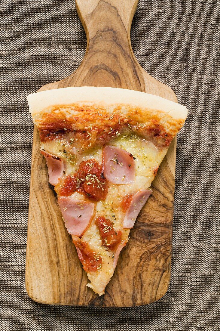 Slice of ham pizza on server