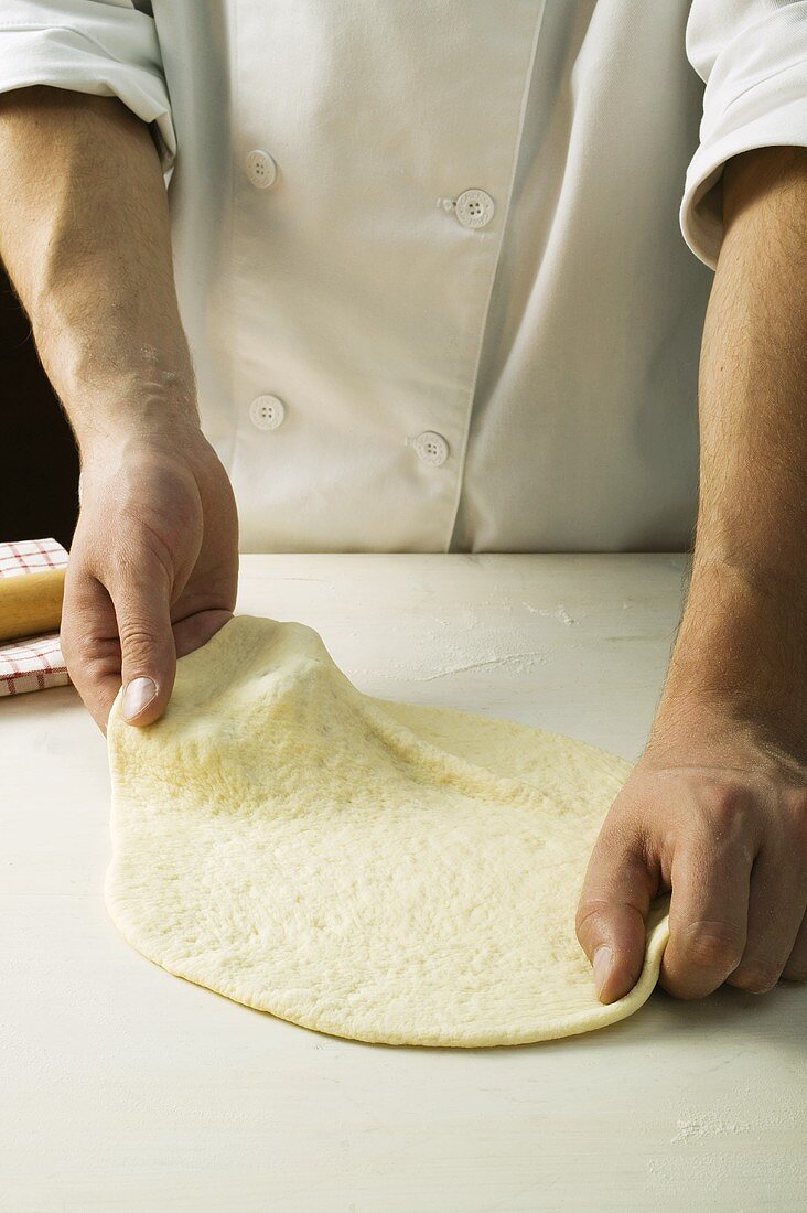 Pizzateig mit den Händen formen (ausziehen)