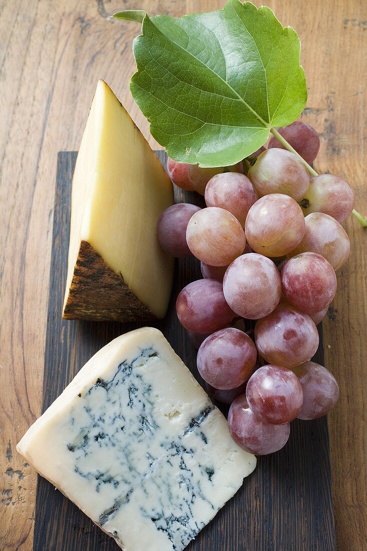 Pieces of Appenzeller and blue cheese with red grapes
