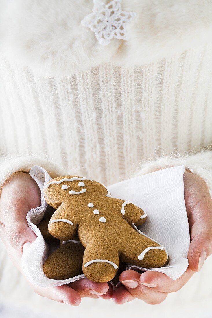 Hands holding two gingerbread men