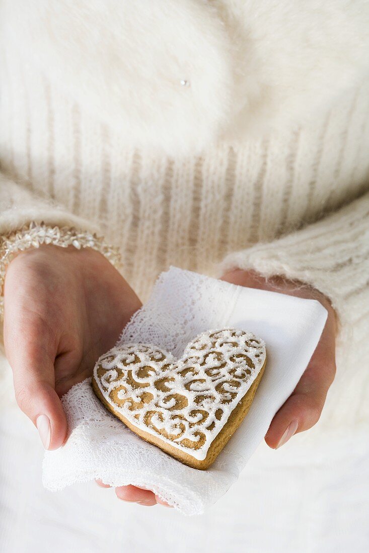 Hands holding gingerbread heart on napkin (Christmassy)