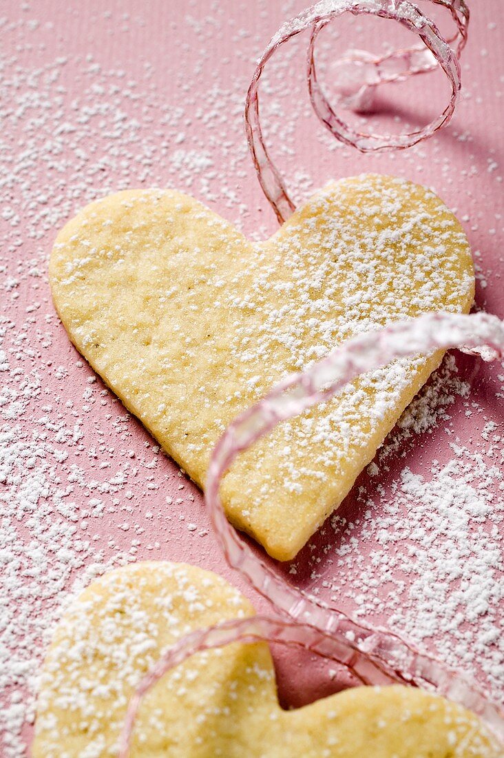 Pastry hearts with icing sugar and pink ribbon