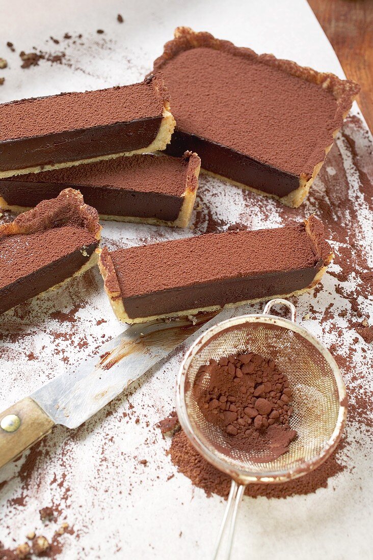 Rechteckige Schokoladentarte mit Kakaopulver, angeschnitten