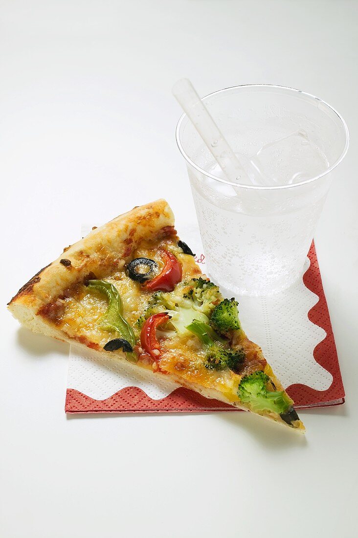 Slice of American-style vegetable pizza and mineral water