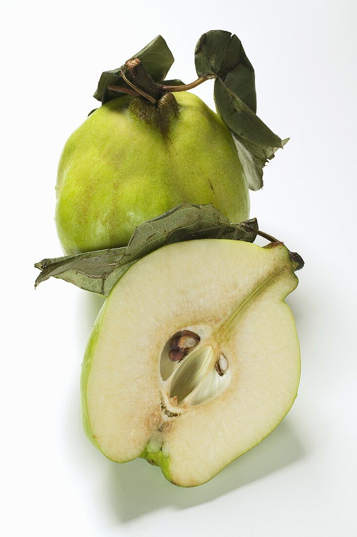 Whole and half quince with leaves