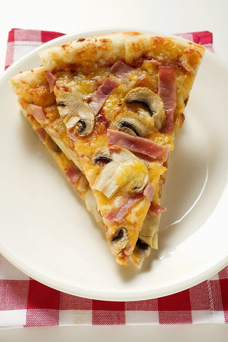 Slices of American-style ham and mushroom pizza