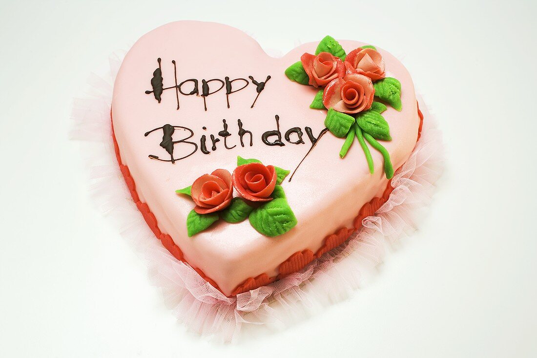 Pink heart-shaped birthday cake with marzipan roses
