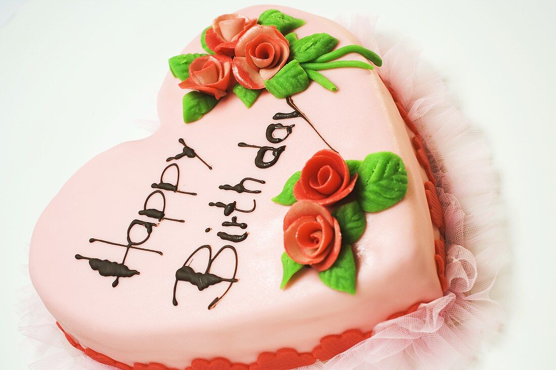 Herzförmige rosa Geburtstagstorte mit Marzipanrosen