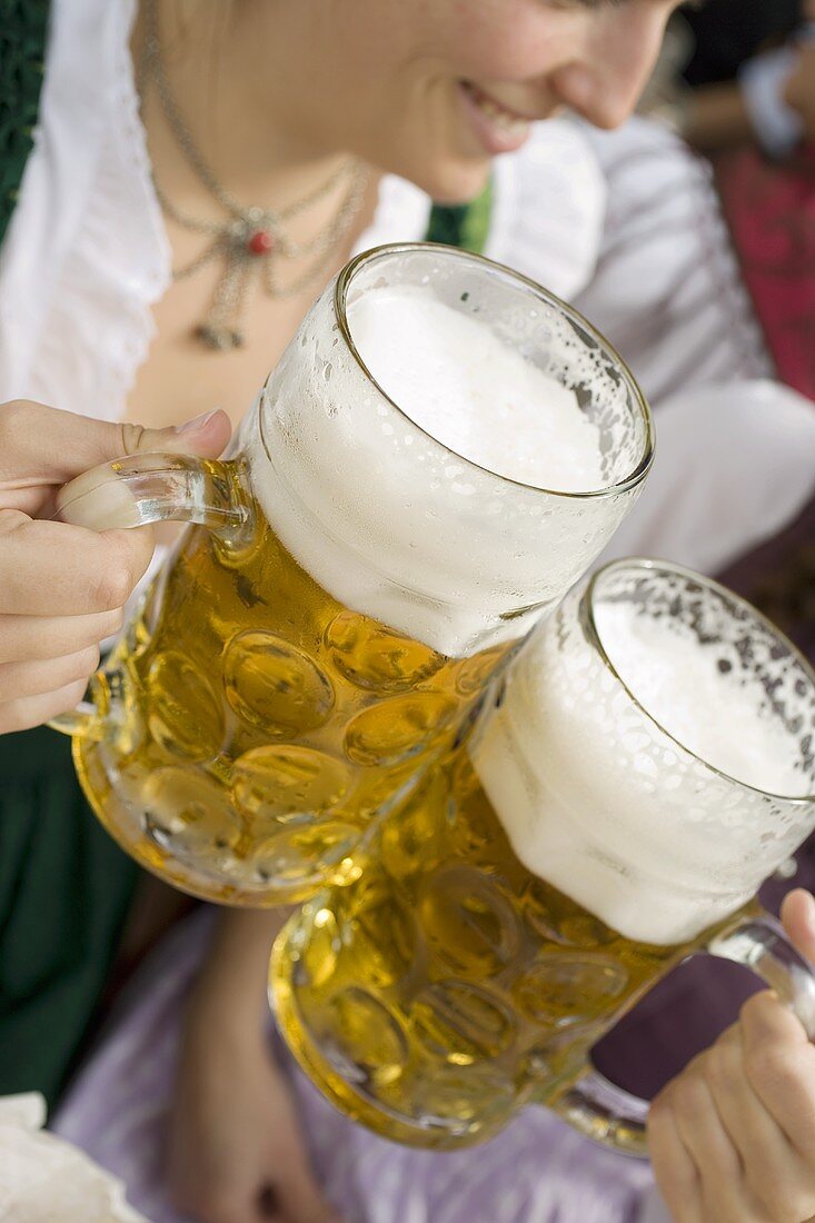 Frauen stossen mit zwei Mass Bier an (München, Oktoberfest)