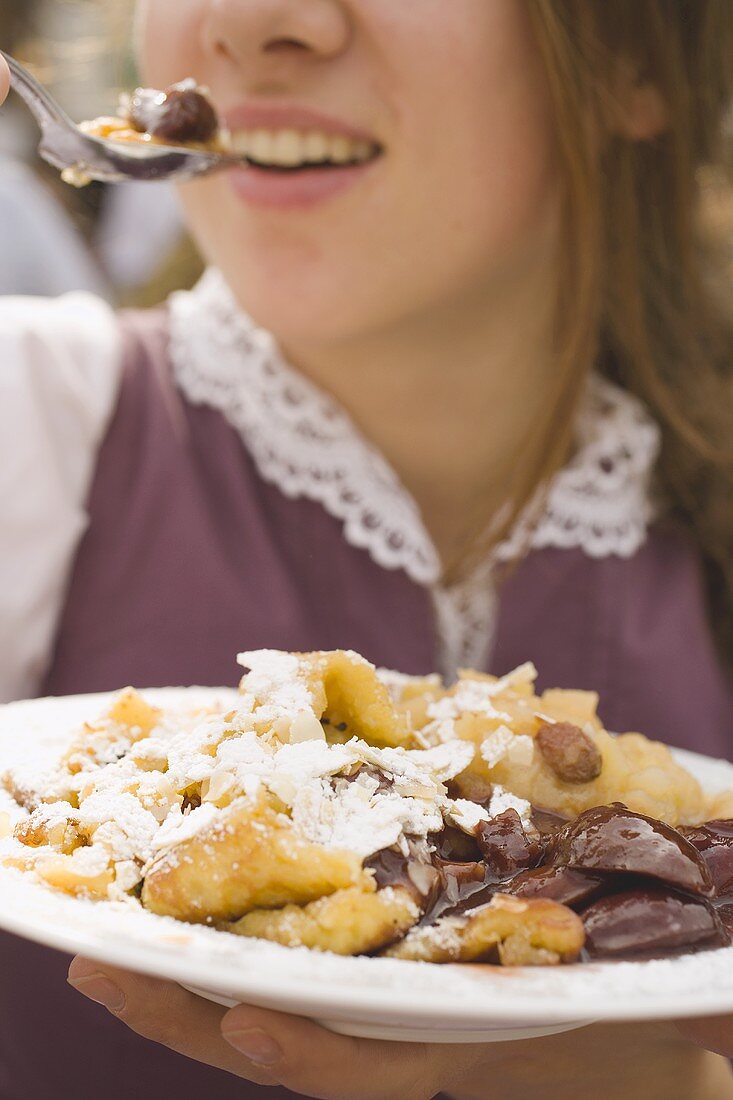 Frau isst Kaiserschmarrn (München, Oktoberfest)