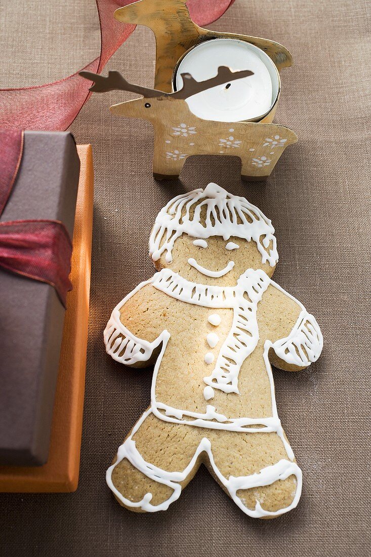 Gingerbread man beside Christmas gifts