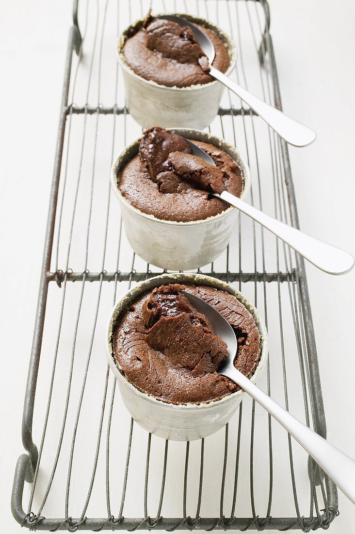 Three small chocolate soufflés filled with chocolate sauce