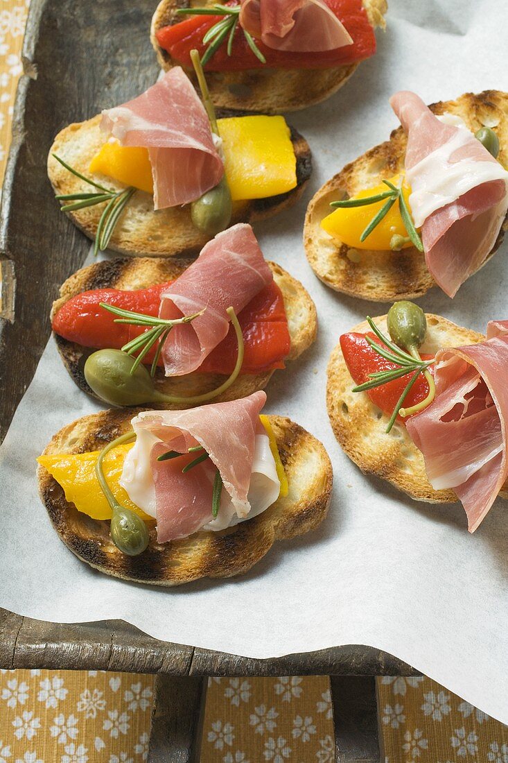 Crostini with raw ham, peppers and giant capers