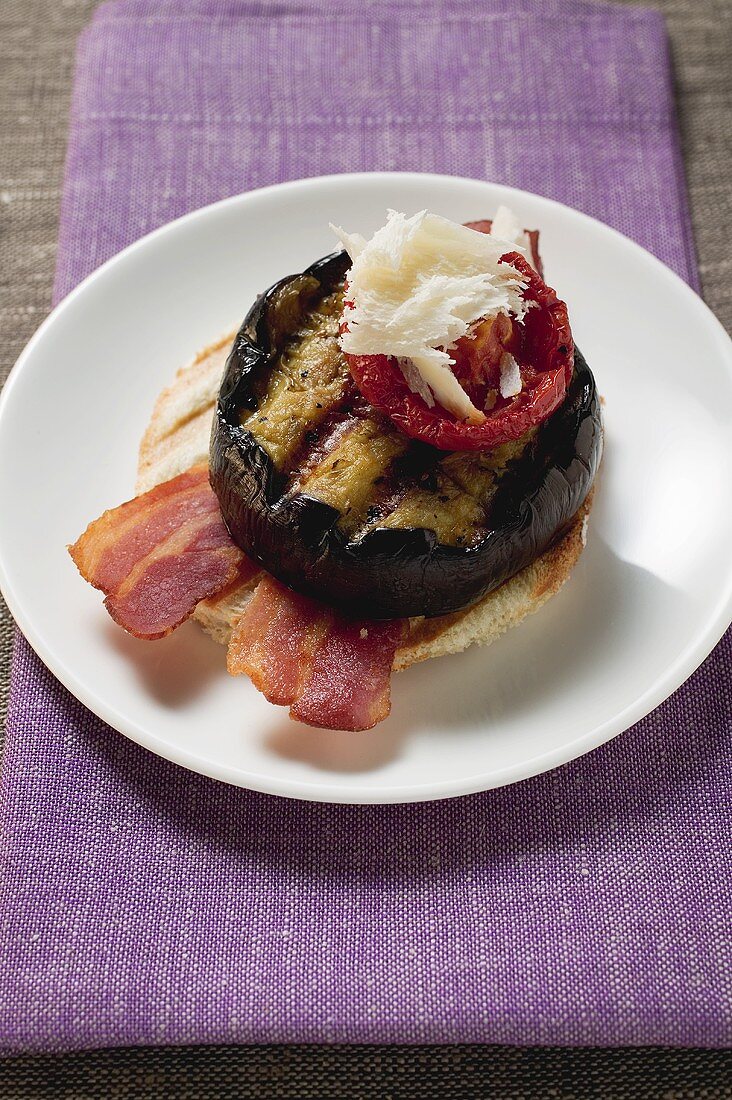 Toast mit Bacon, gegrillter Aubergine, Tomate und Parmesan