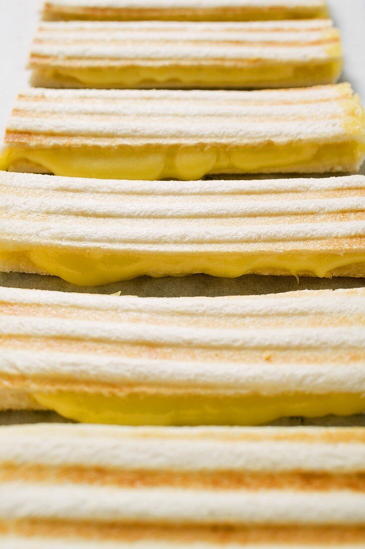 Several toasted cheese sandwiches in a row (detail)