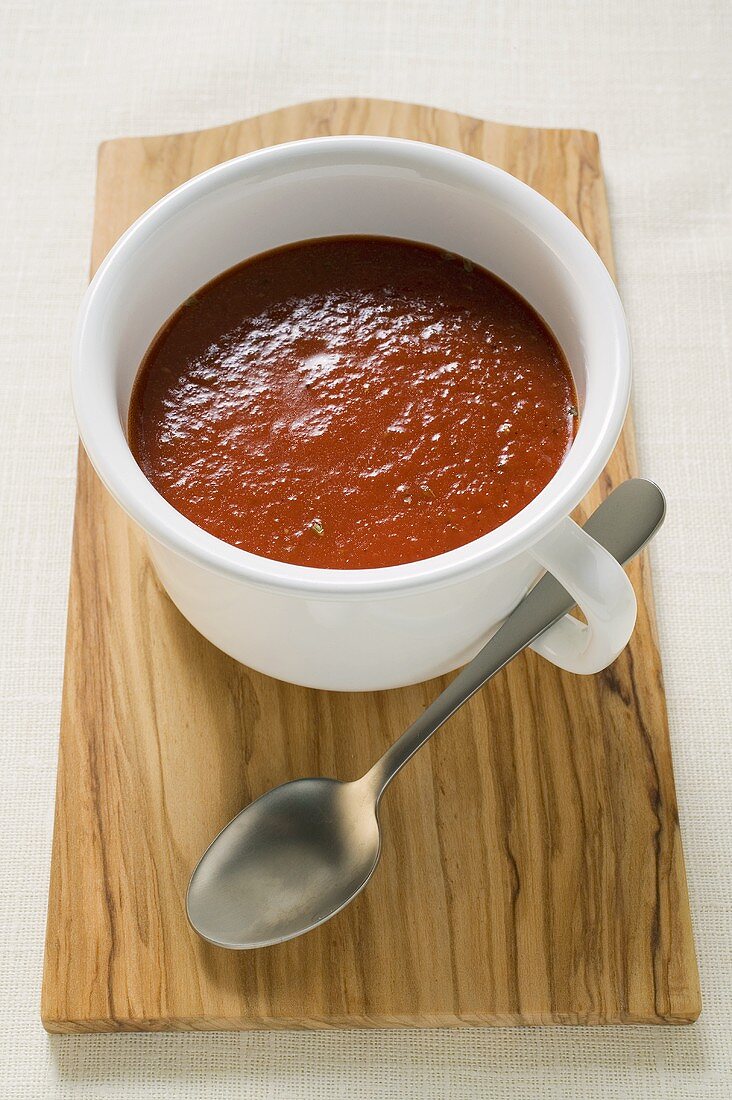 Tomatensuppe in Tasse auf Schneidebrett