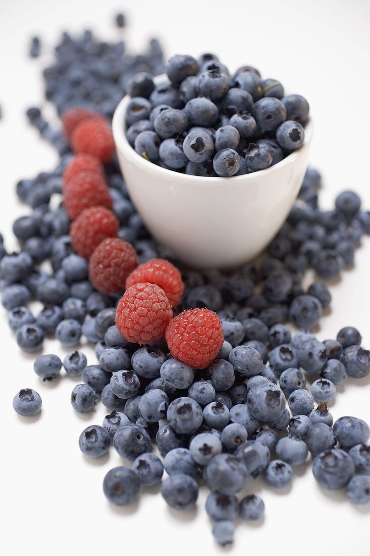 Blueberries and raspberries, some in bowl