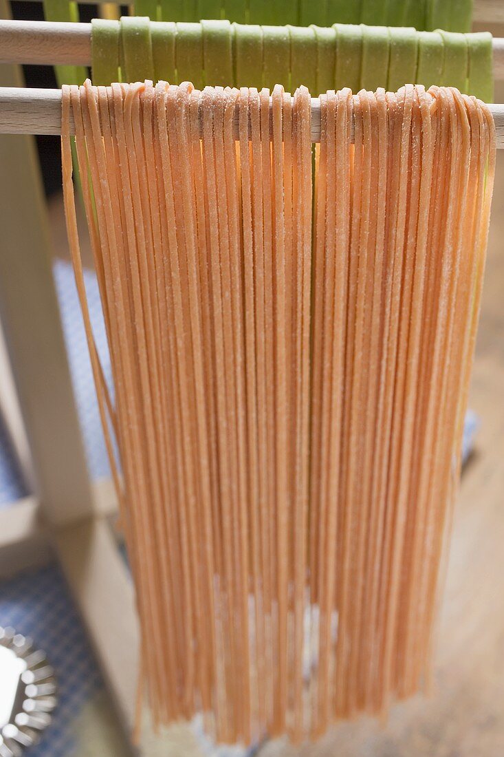 Home-made red pasta, hanging up to dry