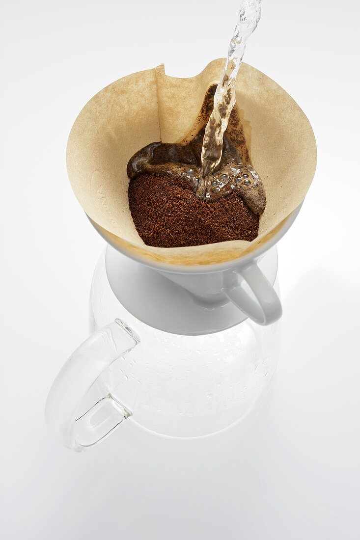 Heisses Wasser auf Kaffeepulver im Filter gießen